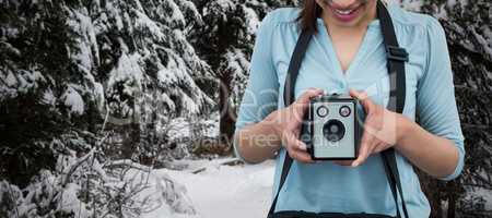 Composite image of smiling female photographer holding vintage camera