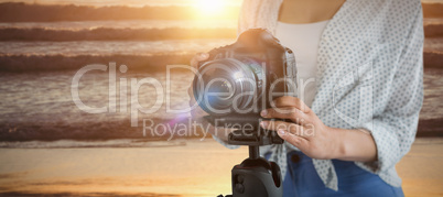 Composite image of mid section of female photographer with digital camera