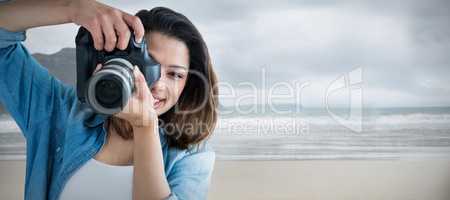 Composite image of portrait of young woman photographing through camera
