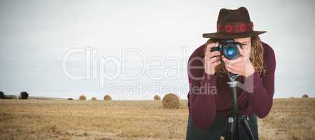 Composite image of young photographer photographing through camera on tripod