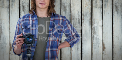 Composite image of portrait of young confident photographer holding camera