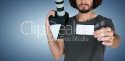 Composite image of portrait of serious male photographer showing card while holding camera