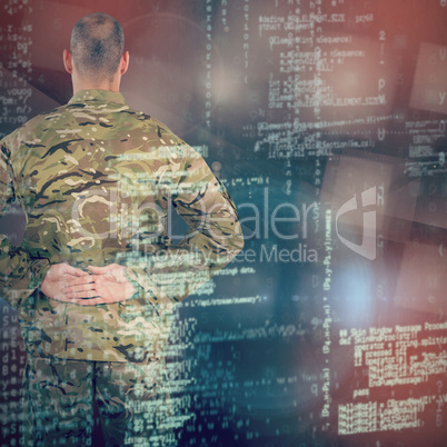 Composite image of rear view of soldier standing with his hands behind back