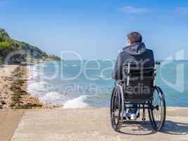 Back of disabled man in wheelchair at beach