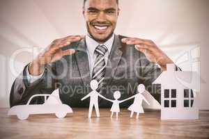 Composite image of businessman smiling behind car, family and house illustration