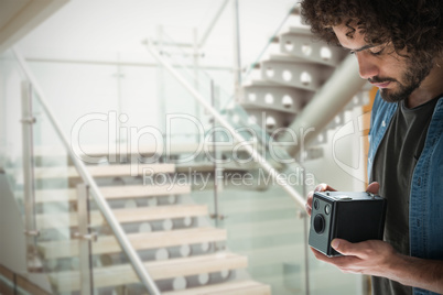 Composite image of young male photographer holding vintage camera