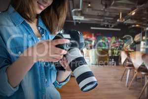 Composite image of young female photographer looking at camera