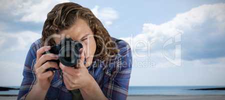 Composite image of photographer photographing  through digital camera