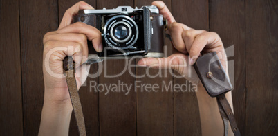 Composite image of cropped image of hands holding camera