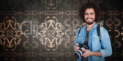Composite image of portrait of happy photographer holding digital camera