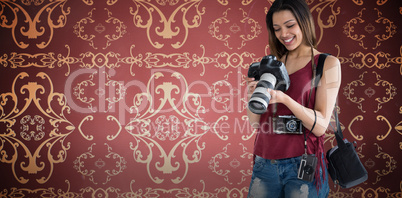 Composite image of smiling young woman holding digital camera