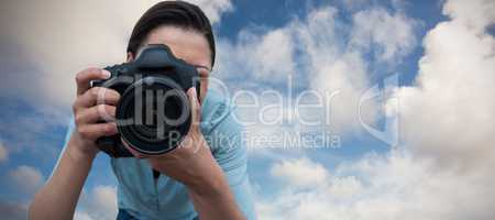 Composite image of female photographer photographing through digital camera