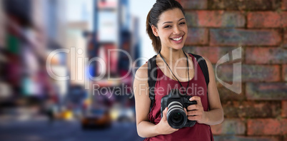Composite image of portrait of happy female photographer with digital camera