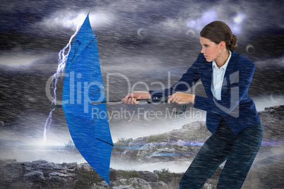 Composite image of businesswoman holding blue umbrella