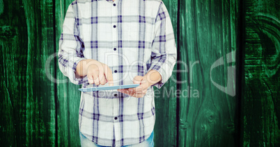 Composite image of mid section of man using digital tablet