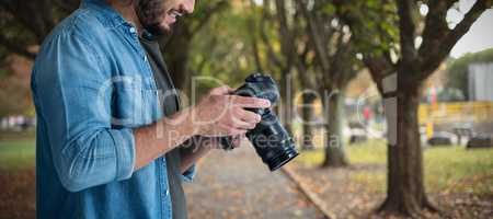 Composite image of smiling male photographer using camera