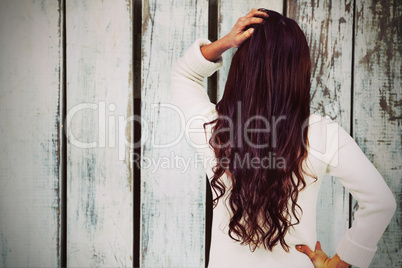 Composite image of full length rear view of brunette with hand in hair
