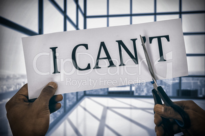 Composite image of conceptual image of businessman cutting paper that reads we cant