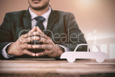 Composite image of business man sitting behind a desk