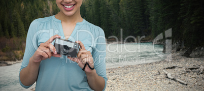 Composite image of portrait of cheerful female photographer with camera