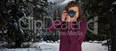 Composite image of young male photographer photographing through camera