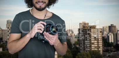 Composite image of portrait of confident smiling male photographer holding camera