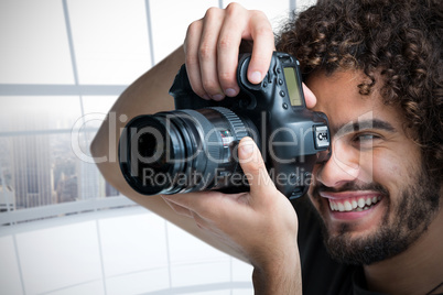 Composite image of close up of cheerful male photographer taking picture with camera