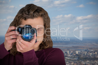 Composite image of male photographer photographing through camera