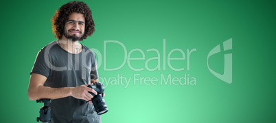Composite image of portrait of happy young photographer holding digital camera
