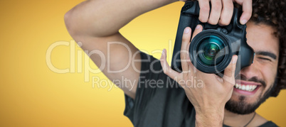 Composite image of smiling male photographer taking picture