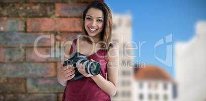 Composite image of portrait of young photographer holding camera