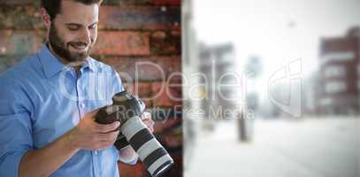 Composite image of smiling male photographer looking at digital camera
