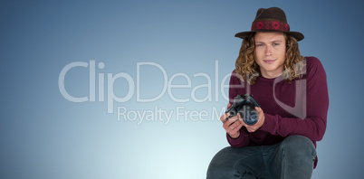 Composite image of portrait of male photographer holding camera while crouching