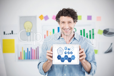 Composite image of businessman showing digital tablet with blank screen in creative office