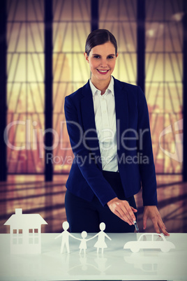 Composite image of woman drawing a car, a family and a house