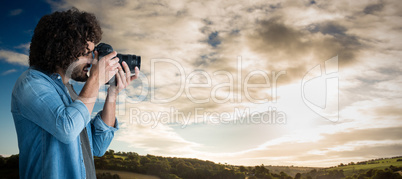 Composite image of male photographer taking picture with digital camera