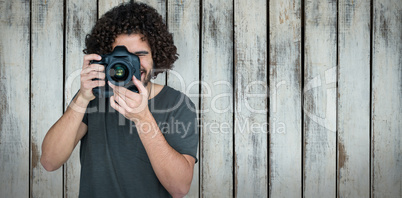 Composite image of man photographing with digital camera