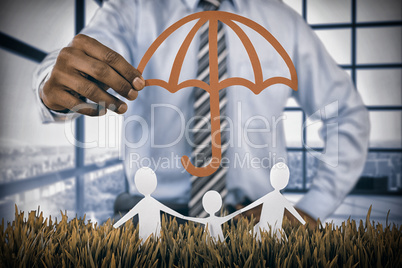 Composite image of family protected by a red umbrella