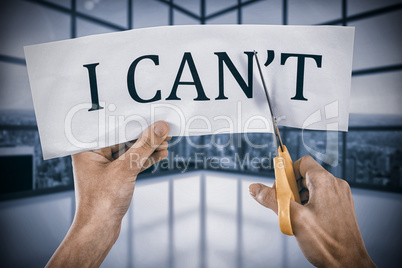 Composite image of conceptual image of businesswoman cutting paper that reads we cant