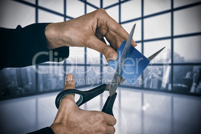 Composite image of businesswoman cutting credit card with scissors