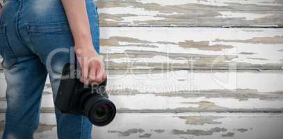 Composite image of mid section of woman holding digital camera