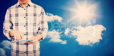 Composite image of mid section of man using digital tablet