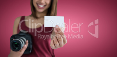 Composite image of happy woman showing identity card while holding camera