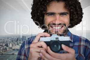 Composite image of close up portrait of smiling photographer holding camera