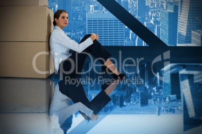 Composite image of businesswoman leaning on cardboard boxes against white background