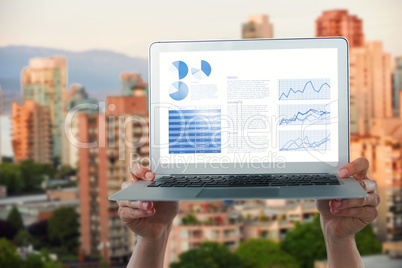 Composite image of cropped hands holding laptop