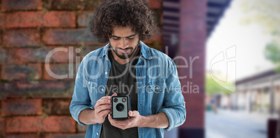 Composite image of male photographer looking at vintage camera