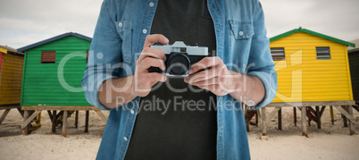 Composite image of mid section of man holding camera