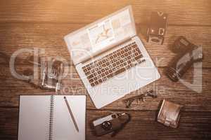 Composite image of close-up of laptop with cameras on table