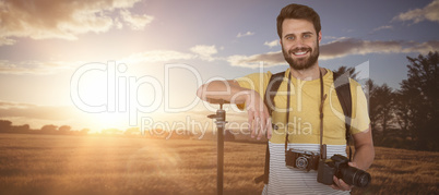 Composite image of portrait of confident young photographer holding digital camera